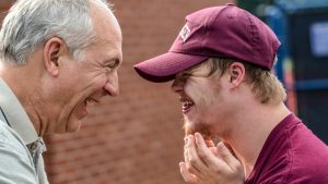 Young adult with an intellectual disability sharing a joyful moment with a a family member during a community outing in Melbourne.