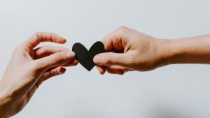 Hands holding a heart to suggest the care of NDIS support workers