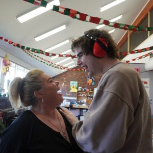 an ndis support worker has fun with a participant in a room with banners