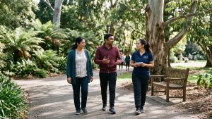 Family carer and NDIS participant enjoying a peaceful walk through a Melbourne botanical garden with a support worker.
